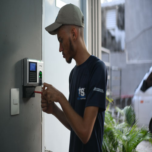 Técnico instalando un lector biométrico de control de acceso
